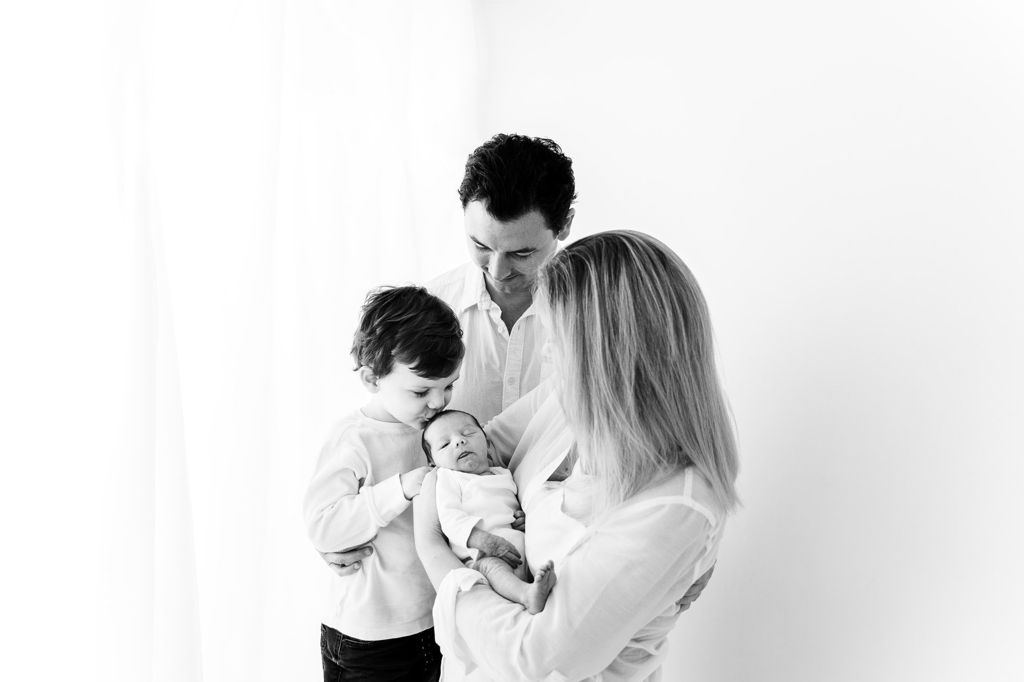 newborn photoshoot norwich captures photo of family cuddling 