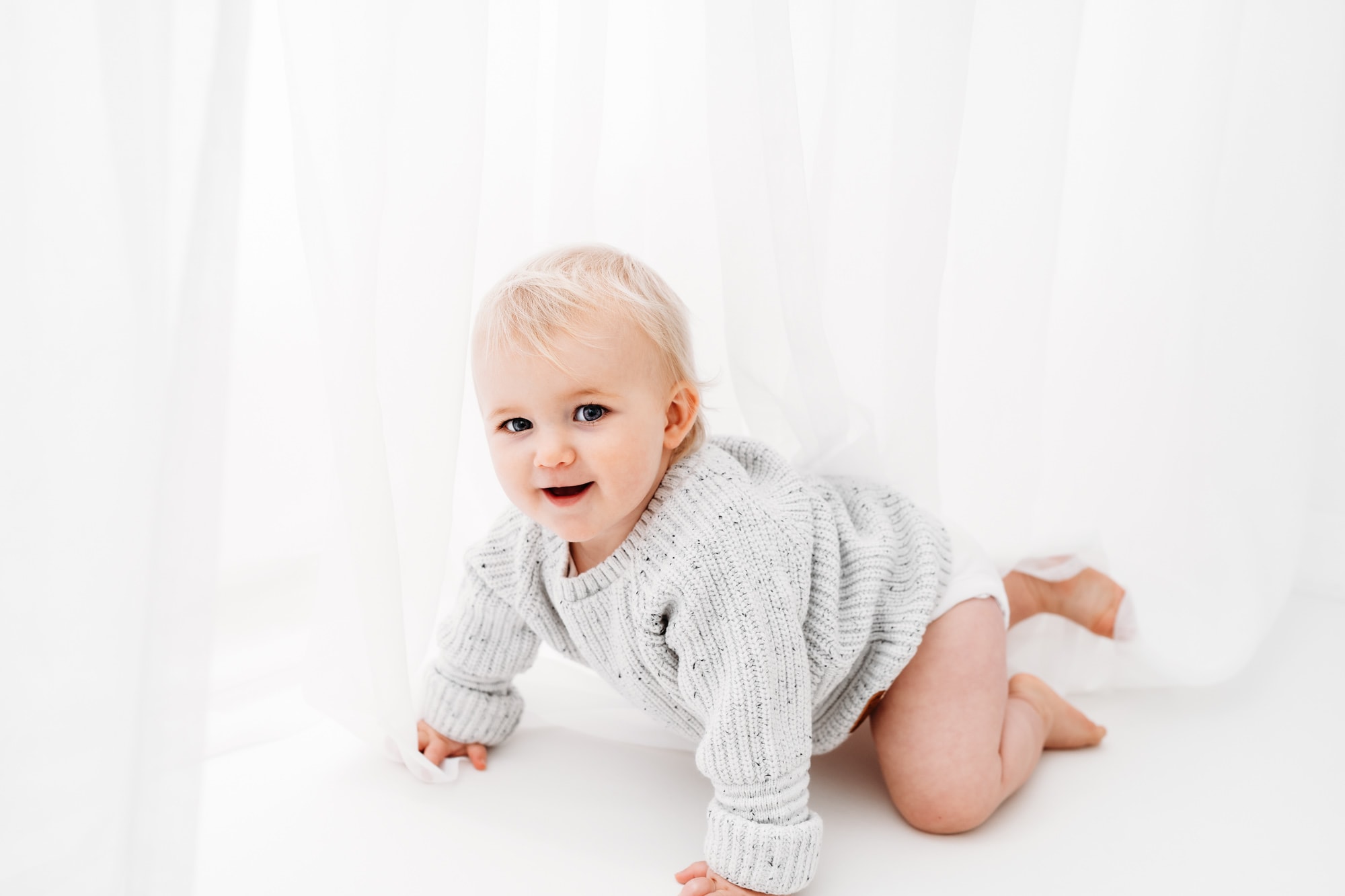norwich baby photographer phtoographs little girl crawling toward camera smiling